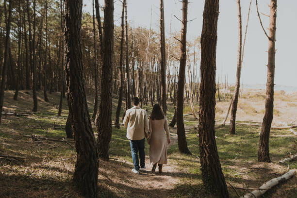 istock Rear view of a couple walking in a forest 1387436183