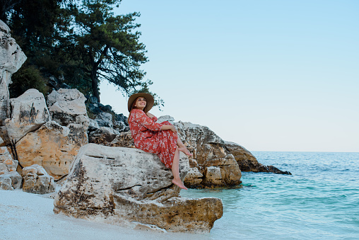 Young woman on a Greece Thassos island, Aegean Sea, Stone beach, and turquoise water.