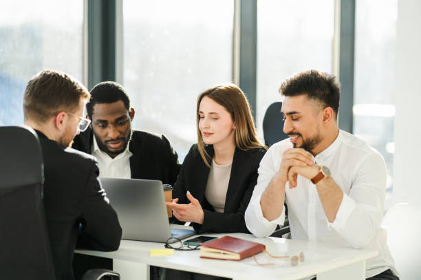 istock Young female office worker presenting a new company development strategy to her colleagues 1387436722