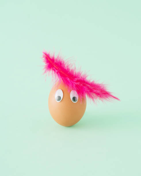 istock Creative arrangement made of egg and pink feather on a green background. Minimal Easter concept. 1387437529