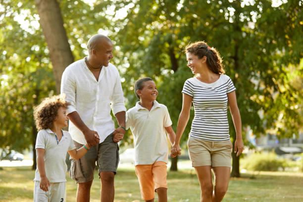 istock Happy couple spending time with their sons in the park 1387437930