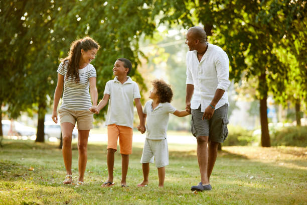 istock Happy couple spending time with their sons in the park 1387437985
