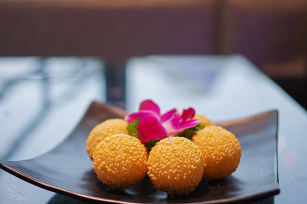 istock Fried sesame balls on black plate with flower as garnish 1387440572