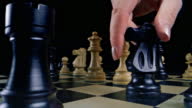 istock DS White female hand taking the king with the knight on the chess board 1387440647