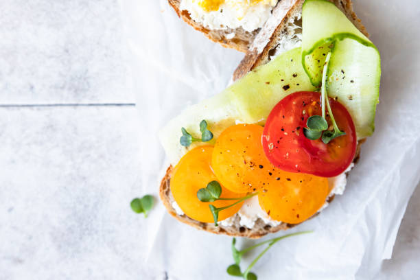 istock Healthy breakfast or lunch with sourdough bread, cream cheese, vegetables and scrambled eggs, tiled background. Top view. 1387440740