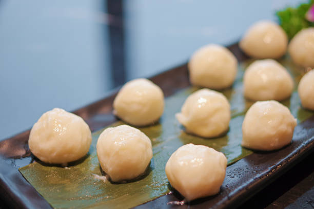 istock Fresh raw small white fish balls for hot pot on black plate 1387440871