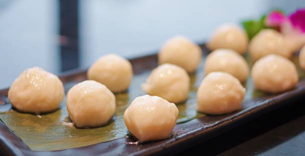 istock Fresh raw small white fish balls for hot pot on black plate close up view 1387440924