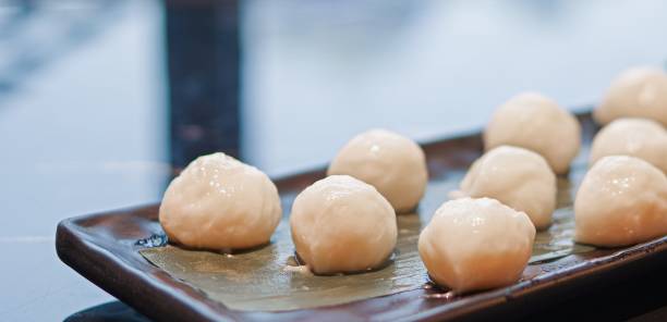 istock Fresh raw handmade fish balls for hot pot on black plate close up view 1387440948