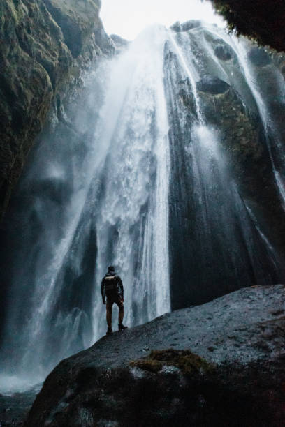 istock The man standing against the Gljufrabui Waterfall in Iceland 1387440970