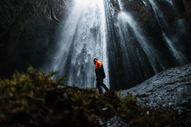 istock The man standing against the Gljufrabui Waterfall in Iceland 1387441027