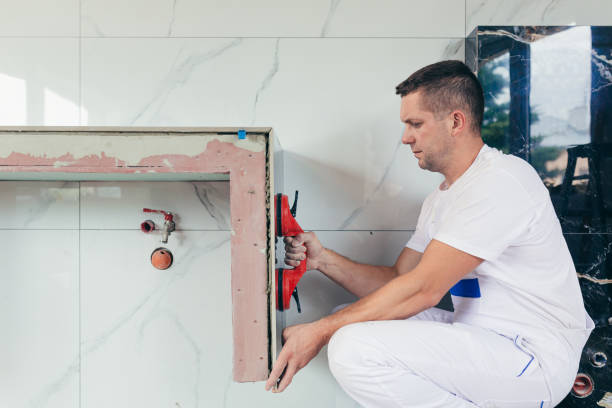 istock A male worker mounts a large ceramic tile in the bathroom 1387441268