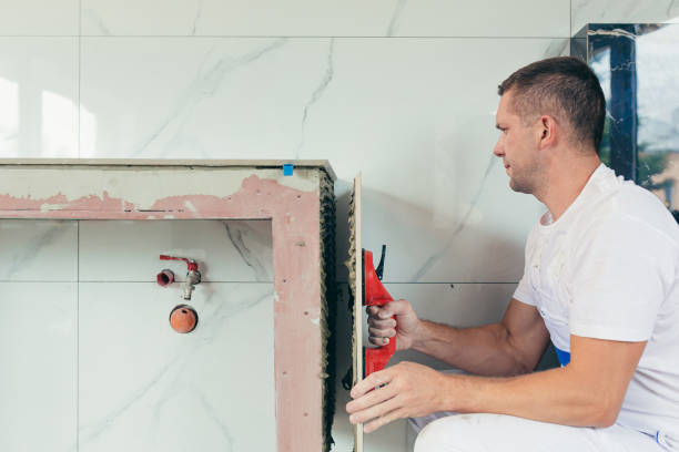istock A male worker mounts a large ceramic tile in the bathroom 1387441272