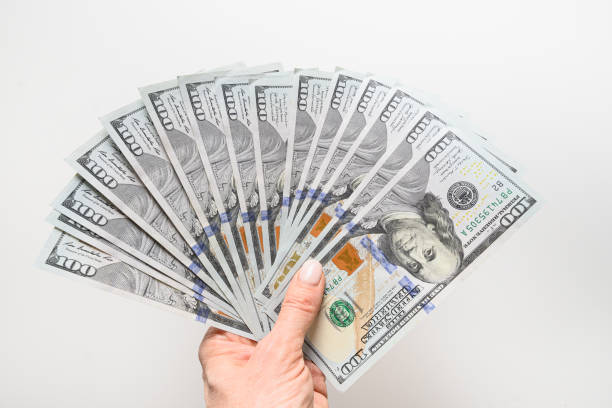 istock Hands holding american 100 dollars bills for payments. Closeup. 1387442948