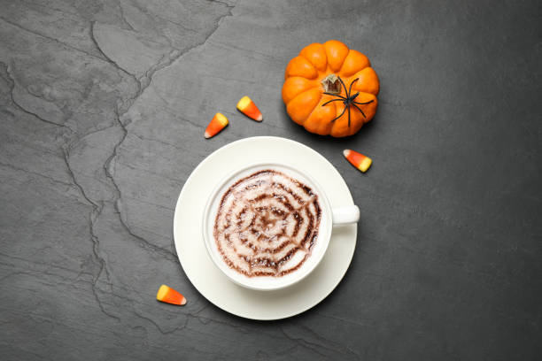 istock Flat lay composition of coffee with spider's net latte art on grey table. Halloween celebration 1387445089