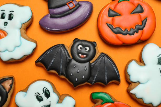 istock Different decorated gingerbread cookies on orange background, flat lay. Halloween celebration 1387445298