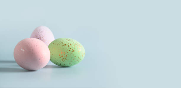 istock Three violet decorative pastel eggs. Happy Easter greeting card with copy space. Top view. 1387445347
