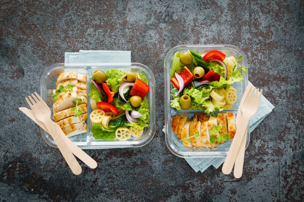 istock Lunch boxes with grilled chicken breast and pasta salad with fresh vegetables. Top view 1387445618