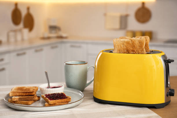 istock Modern toaster and tasty breakfast on wooden table in kitchen 1387445858