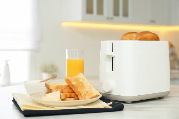istock Modern toaster and tasty breakfast on white marble table in kitchen 1387445953