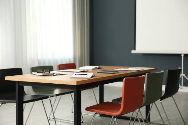 istock Modern meeting room interior with large table and projection screen 1387446024