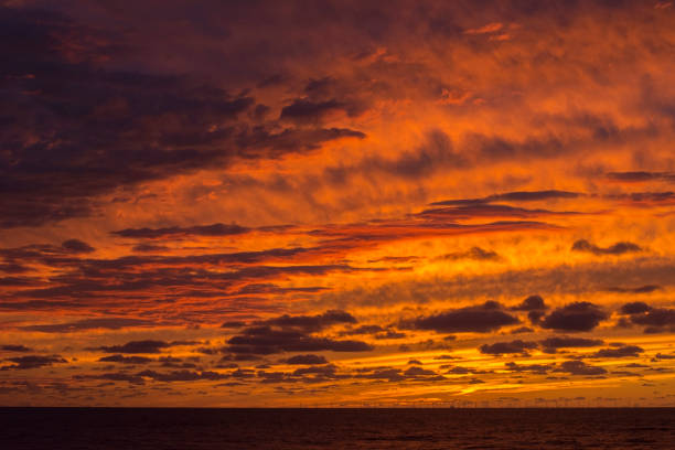 istock Yellow dawn with clouds. Sundown in the ocean. Orange and yellow sky 1387447004