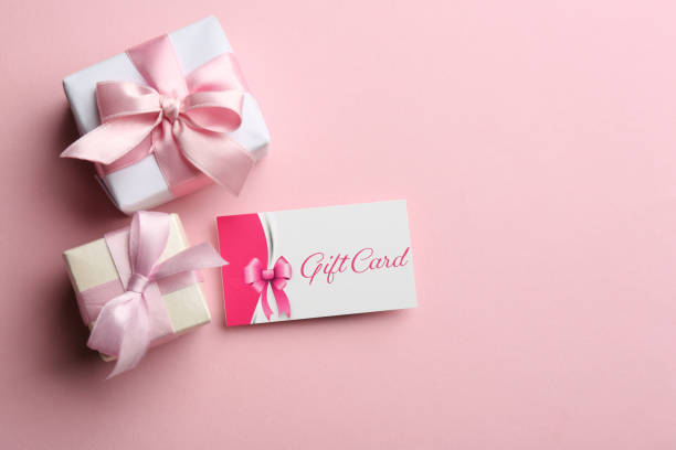 istock Gift card and presents on pink background, flat lay. Space for text 1387447276