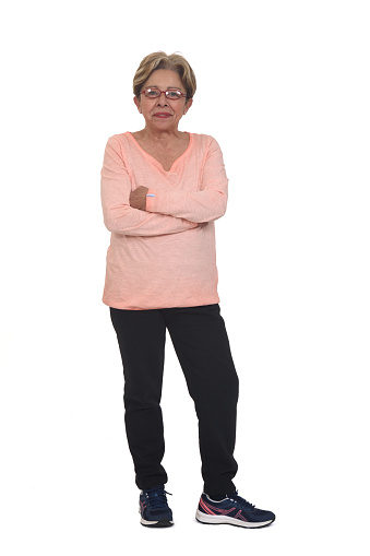 senior woman with sportswear arms crossed on white background