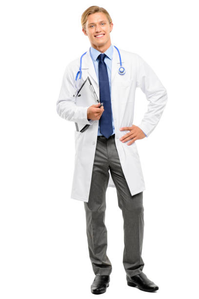 istock Full length shot of a handsome young doctor standing alone in the studio and posing while holding a clipboard 1387449120