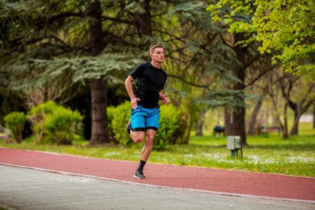istock Young sportive malae in sporty outfit doing some exercise at a park 1387451851