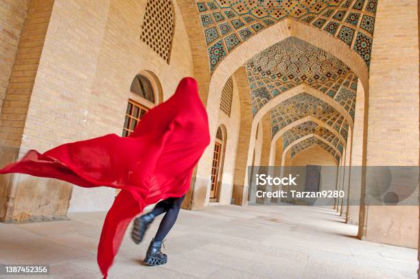 Woman In Red Cloak Running Traditional Iranian Style Courtyard Stock Photo - Download Image Now