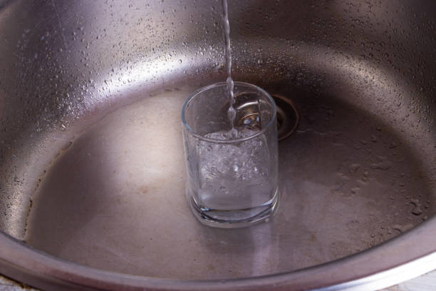 istock Glass of pouring water with reflection 1387453554