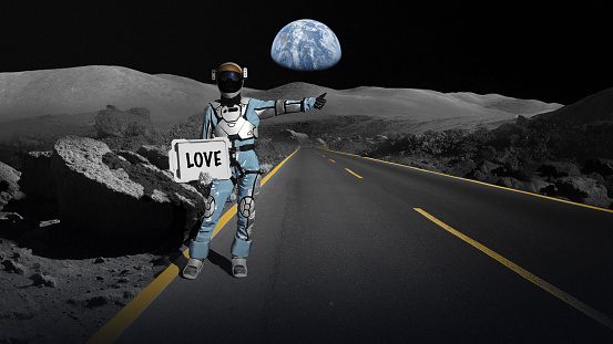 Person in a space suit hitchhiking by the road on the moon. Distant planet earth visible in the background