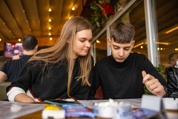 istock Boy and girl reading menu 1387453780