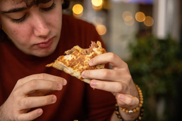 istock Teenager Eating a Wrap Sandwich with Hands 1387456470
