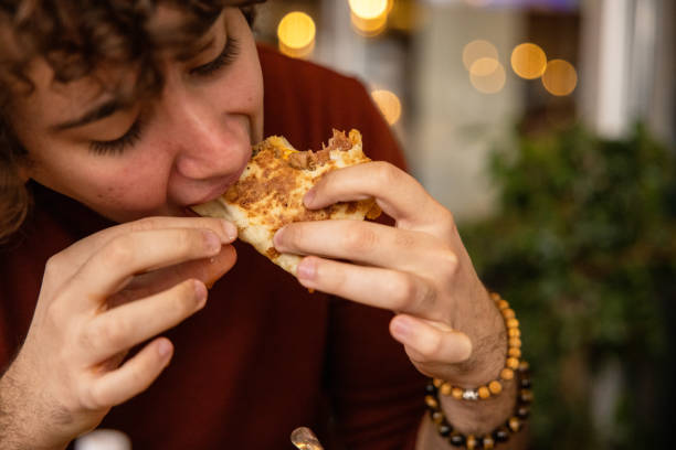 istock Boy eating a wrap sandwich with hands 1387456525
