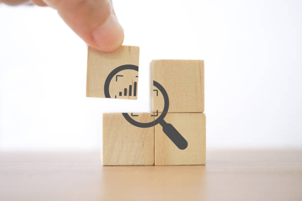 istock hand complete magnifying glass with crop and increasing graph inside icon on wood block for business growth, focus on target concept 1387459373