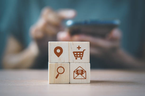 wooden cube blocks with buyer persona icons and blurred woman  for buyer persona and target customer concept. Personalized marketing. Customer analysis for marketing plan, online business strategy stock photo