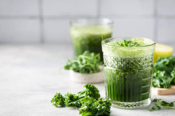 jus détox vert ou smoothie en verre - green smoothie smoothie nutritional supplement leaf vegetable photos et images de collection