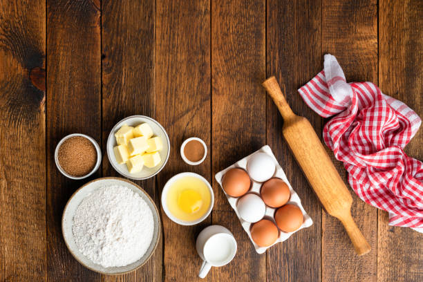 Baking ingredients on rustic wooden table background Baking ingredients on rustic wooden table background. Flour eggs sugar butter and rolling pin on brown wooden planks. Top view copy space easter cake stock pictures, royalty-free photos & images