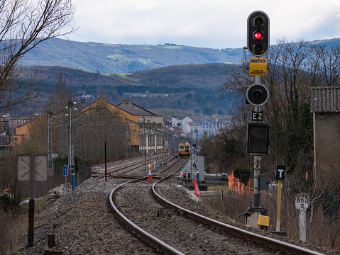 Monforte de Lemos, Lugo, Spain; 03-21-2022; Illuminated signal at the entrance to Monforte station indicating red (stop) during the electrification works and a workshop train working on the track