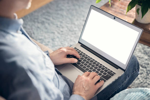 istock Laptop computer on mans lap working from home or in office with blank white screen background 1387461012