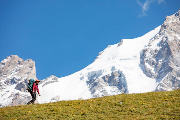 istock Young woman trekking in mountains 1387462639