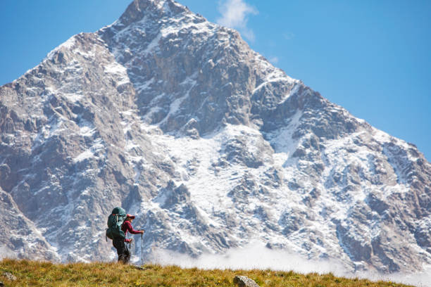istock Young woman trekking in mountains 1387462663