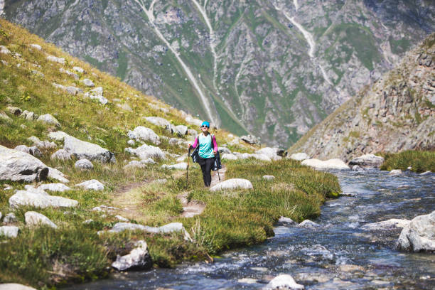 istock Young woman trekking in mountains 1387463112