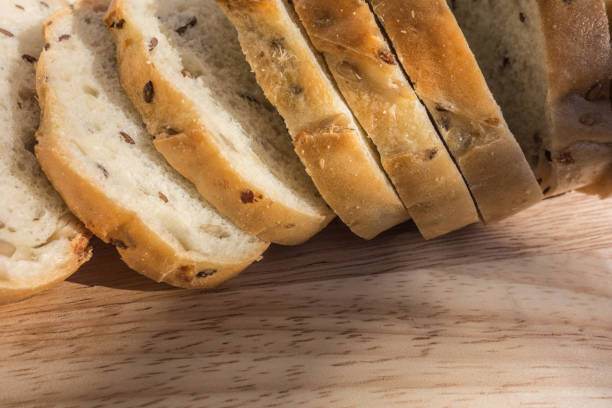 istock Sliced white organic bread with cereal seeds on a wooden background 1387463351