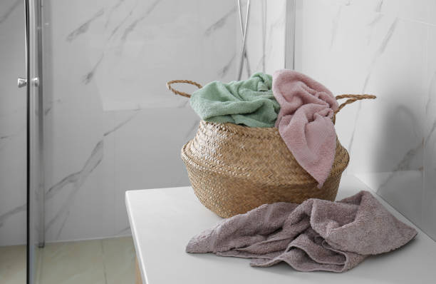istock Wicker laundry basket with towels on countertop in bathroom. Space for text 1387463975