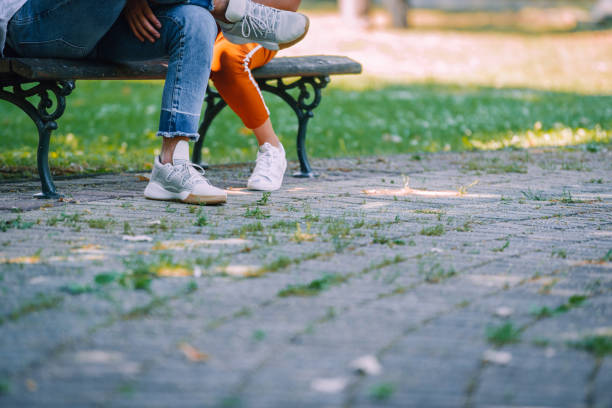 istock Young affectionate couple legs in park in summer 1387464263