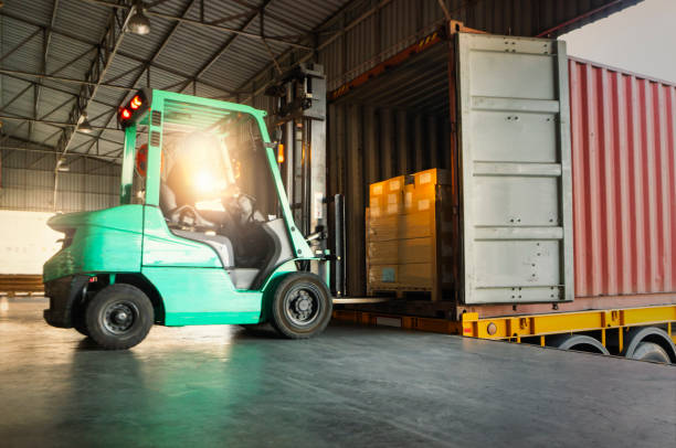 Forklift Tractor Loading Packaging Boxes into Shipping Container at Dock Warehouse. Delivery Cargo Trucks Service. Warehouse Logistics. Shipment Freight Truck Transportation Forklift Tractor Loading Packaging Boxes into Shipping Container at Dock Warehouse. Delivery Cargo Trucks Service. Warehouse Logistics. Shipment Freight Truck Transportation loading bay stock pictures, royalty-free photos & images