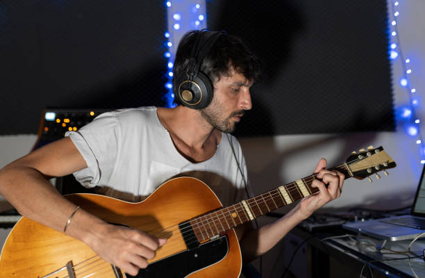istock male composer with guitar in recording studio 1387465647