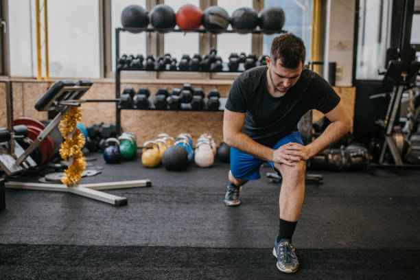 istock Young man exercising in gym 1387467904
